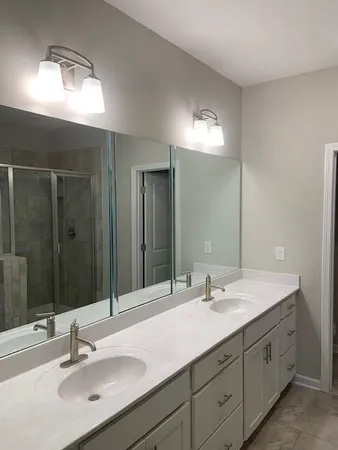 a bathroom with double vanity sinks and a mirror