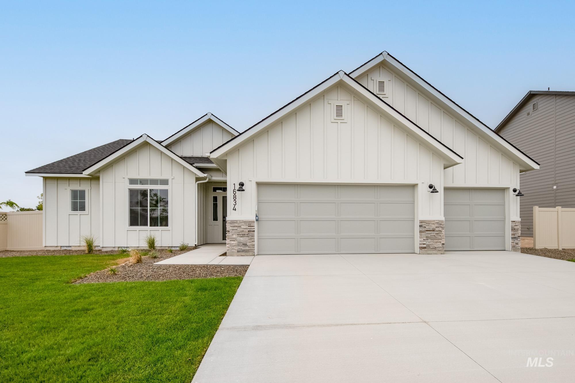 16834 Carlin Avenue Caldwell, ID 83607 - Photo 1 of 1 Modern farmhouse with board and batten siding, concrete driveway, a garage, roof with shingles, and stone siding