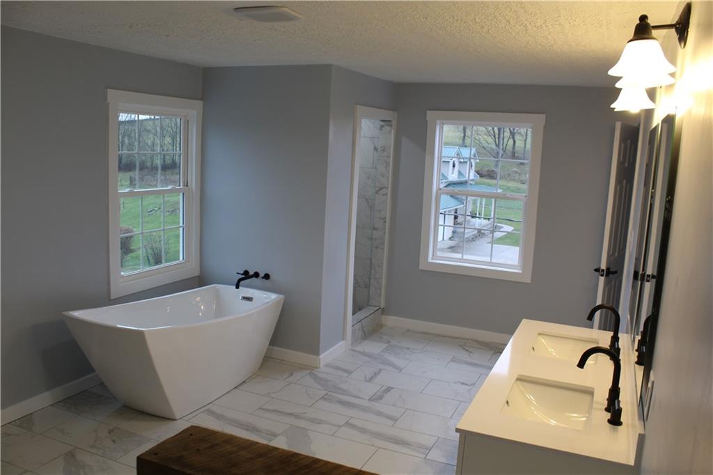 73 Beham Ridge Road West Alexander, PA 15376 - Photo 5 of 20 a white bath tub sitting in a bathroom next to a window
