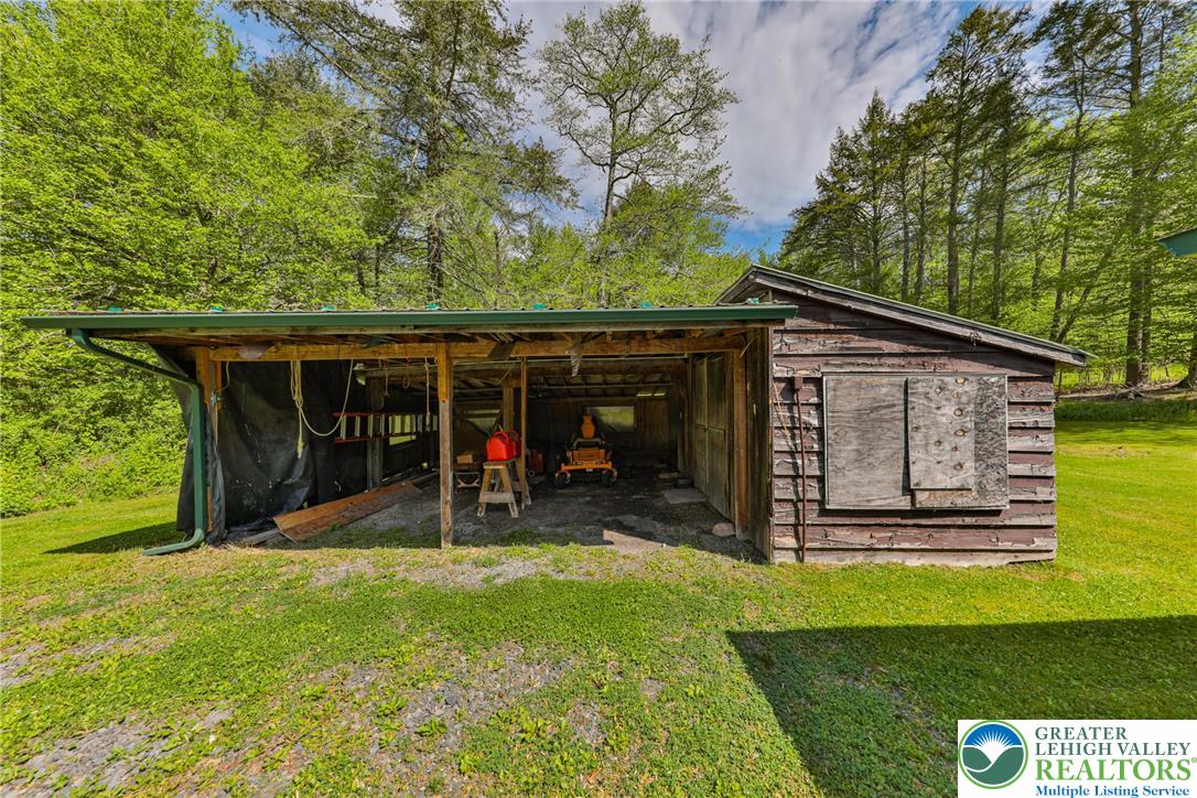 331 Cranberry Creek Road Cresco, PA 18326 - Photo 69 of 95 A rustic outbuilding provides ample storage, nestled against a backdrop of mature trees and a verdant lawn.