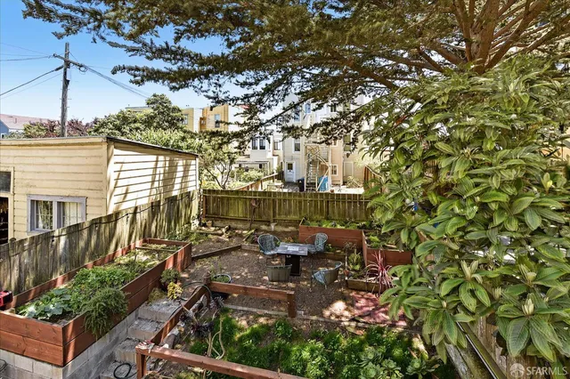 a view of a patio with table and chairs potted plants and large tree