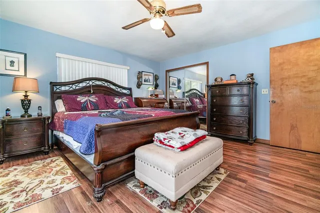 a bedroom with a bed a dresser and a chandelier