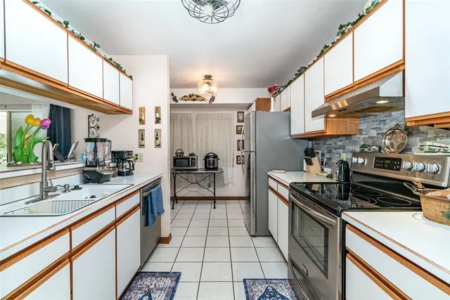 a kitchen with stainless steel appliances a sink stove and cabinets