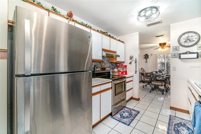 a kitchen with a refrigerator and a stove top oven