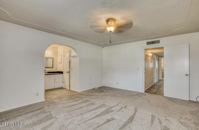 1602 Waterfront Street Anthony, NM 88021 - Photo 26 of 58 an empty room with a chandelier fan and wooden floor