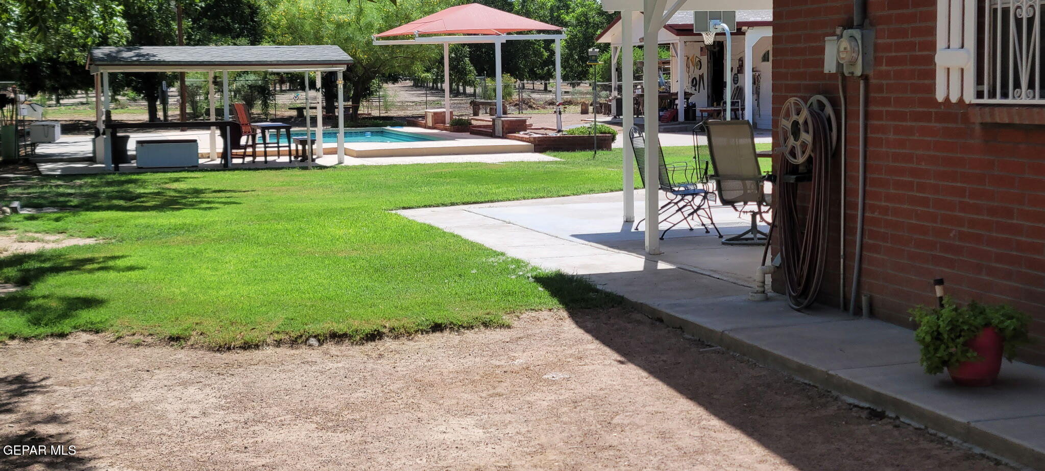 1602 Waterfront Street Anthony, NM 88021 - Photo 49 of 58 a patio with a table and chairs under an umbrella