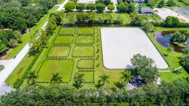 an aerial view of a resort with swimming pool a patio and yard