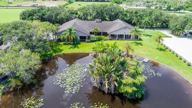 an aerial view of a house with a garden and lake view