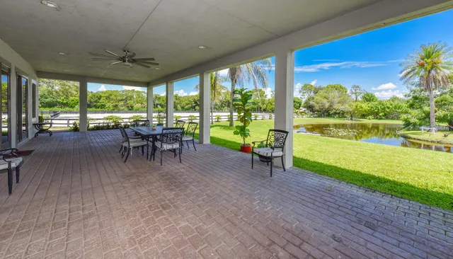a view of a patio with chairs and floor to ceiling window