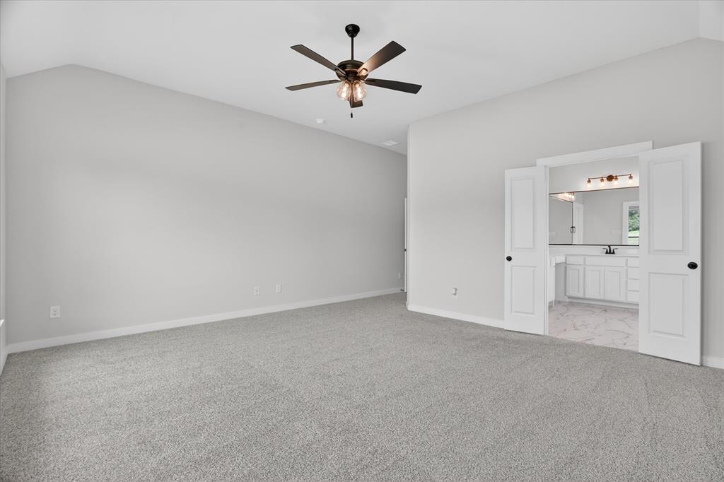 317 Skeen Peak Springtown, TX 76082 - Photo 20 of 31 Spacious carpeted room featuring vaulted ceilings and a ceiling fan with light fixture