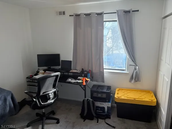 a view of a workspace with furniture and a window