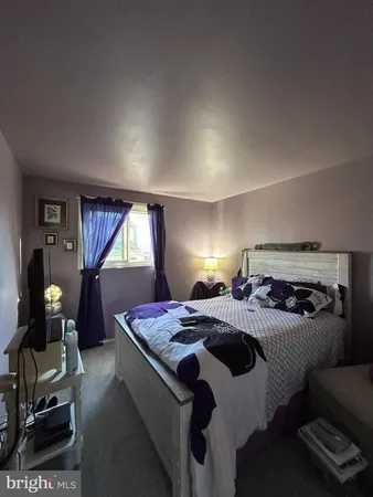 a bedroom with a bed and a dresser next to a window