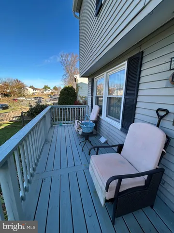a balcony with wooden floor table and chairs