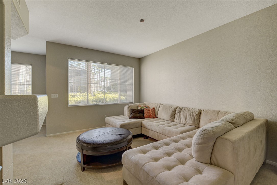 9050 West Warm Springs Road, Unit 1034 Las Vegas, NV 89148 - Photo 5 of 17 A spacious living area features soft carpeting and ample natural light through a large window.