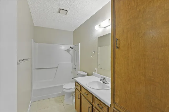 a bathroom with a granite countertop sink a toilet and shower