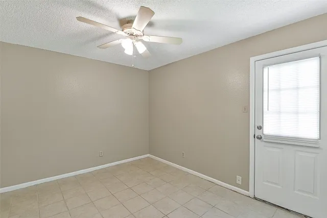an empty room with a window and a fan