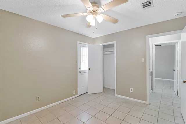 an empty room with fan and entryway