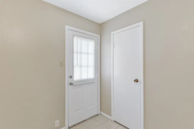 a view of an empty room with wooden floor and closet
