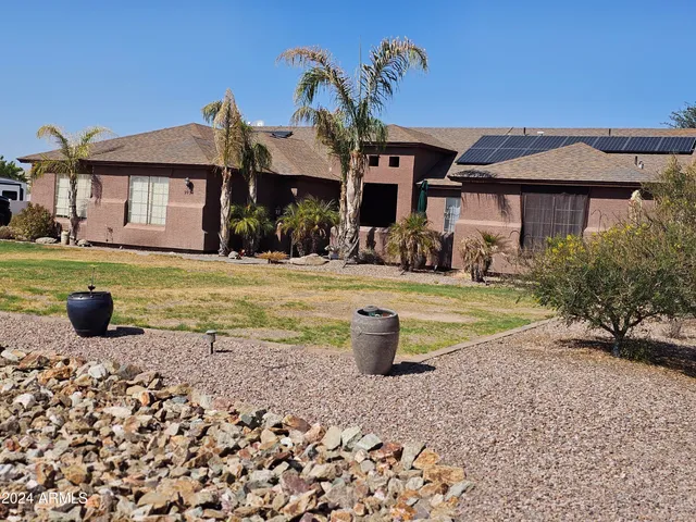 a view of a house with backyard and sitting area
