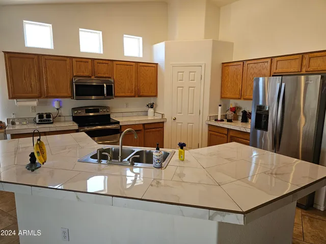 a kitchen with a sink a stove and chairs