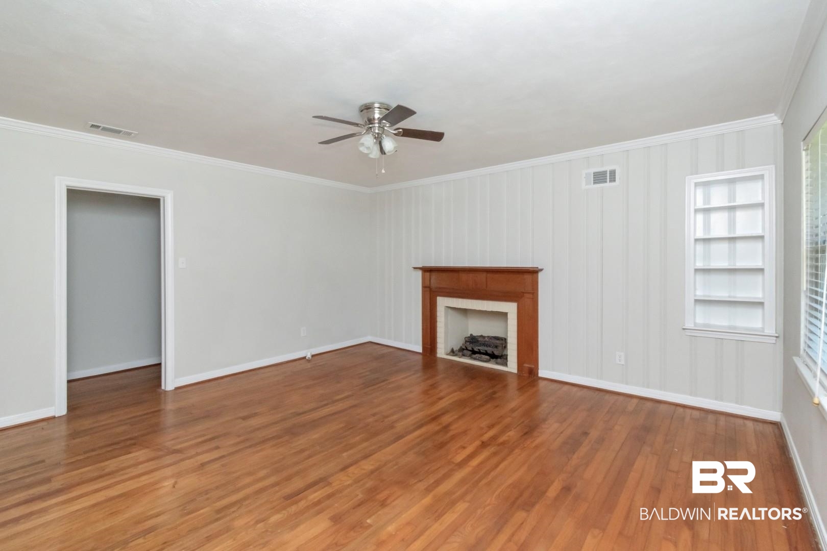 2105 Upham Court Mobile, AL 36607 - Photo 8 of 32 Unfurnished living room with crown molding, light wood finished floors, ceiling fan, and a fireplace