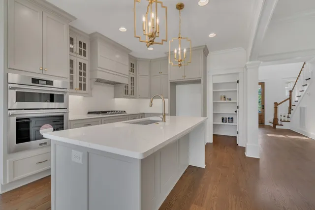 a kitchen that has a lot of cabinets a sink a window and stainless steel appliances
