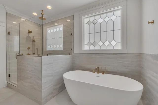 a white bath tub sitting in a bathroom and shower