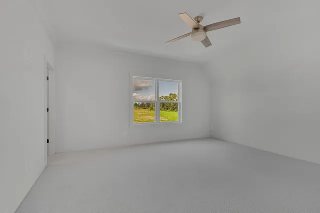 an empty room with a window and a ceiling fan
