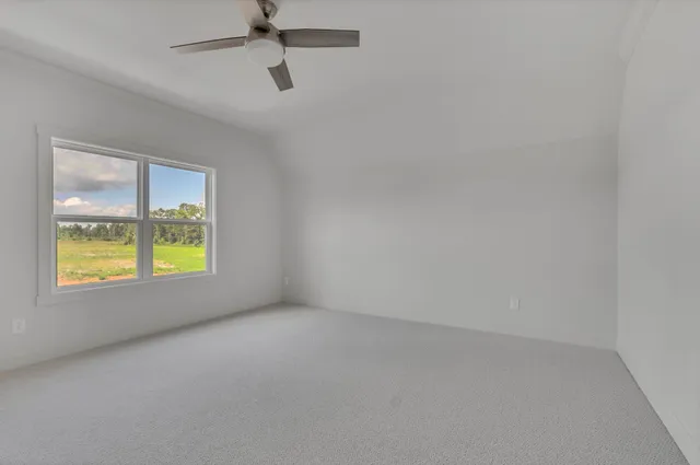 an empty room with a window and a ceiling fan