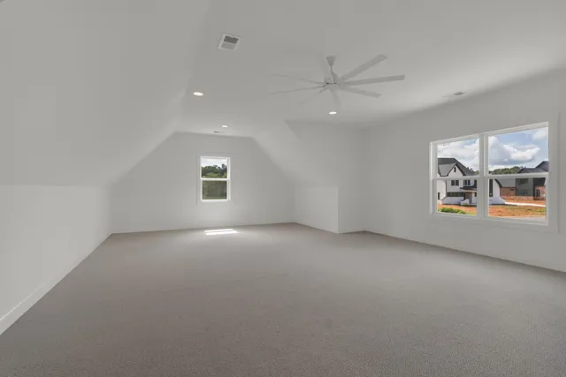 an empty room with windows and fan