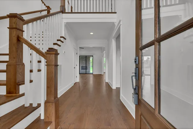 a view of a hallway with wooden floor and staircase