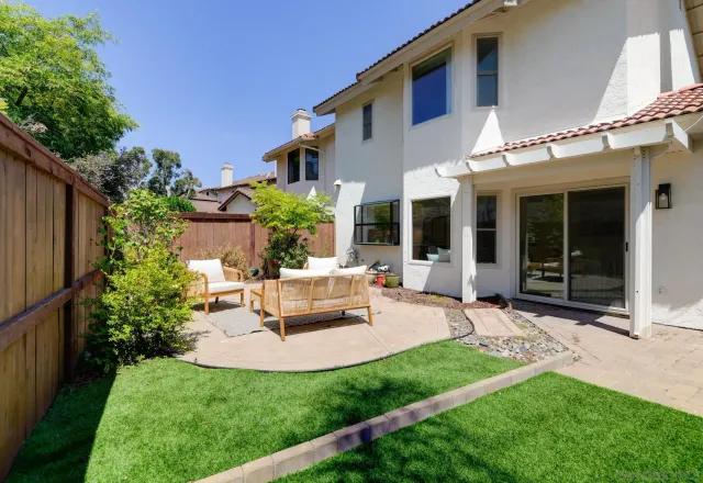 a view of a house with backyard sitting area and garden