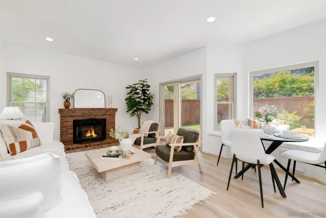 a living room with furniture a fireplace and a large window