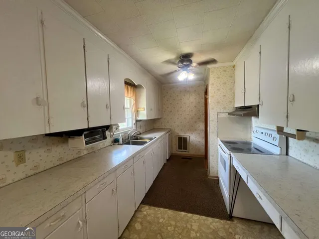an empty room with a window and a fan