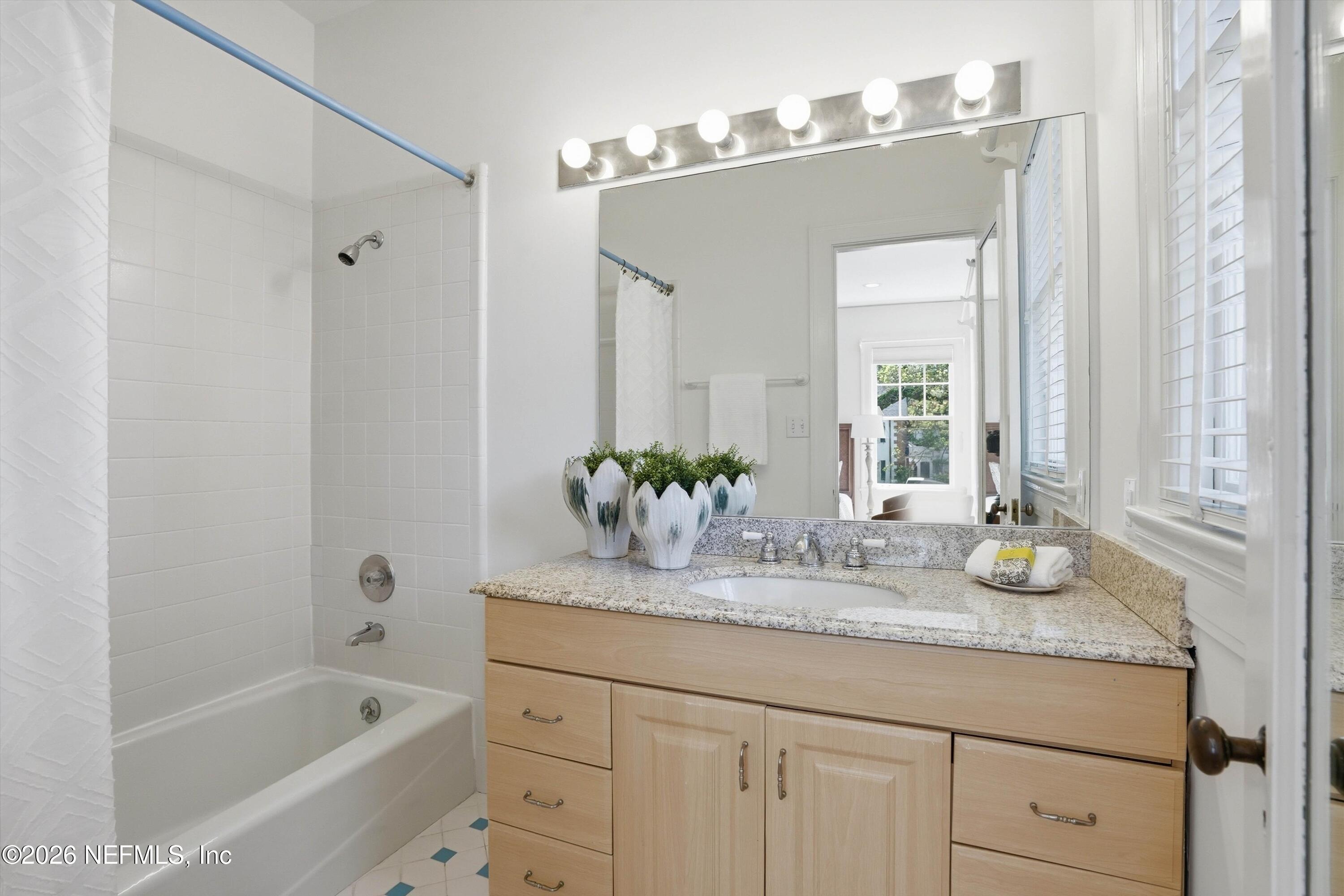 833 Sorrento Road Jacksonville, FL 32207 - Photo 33 of 68 a bathroom with a granite countertop sink a mirror and a bathtub