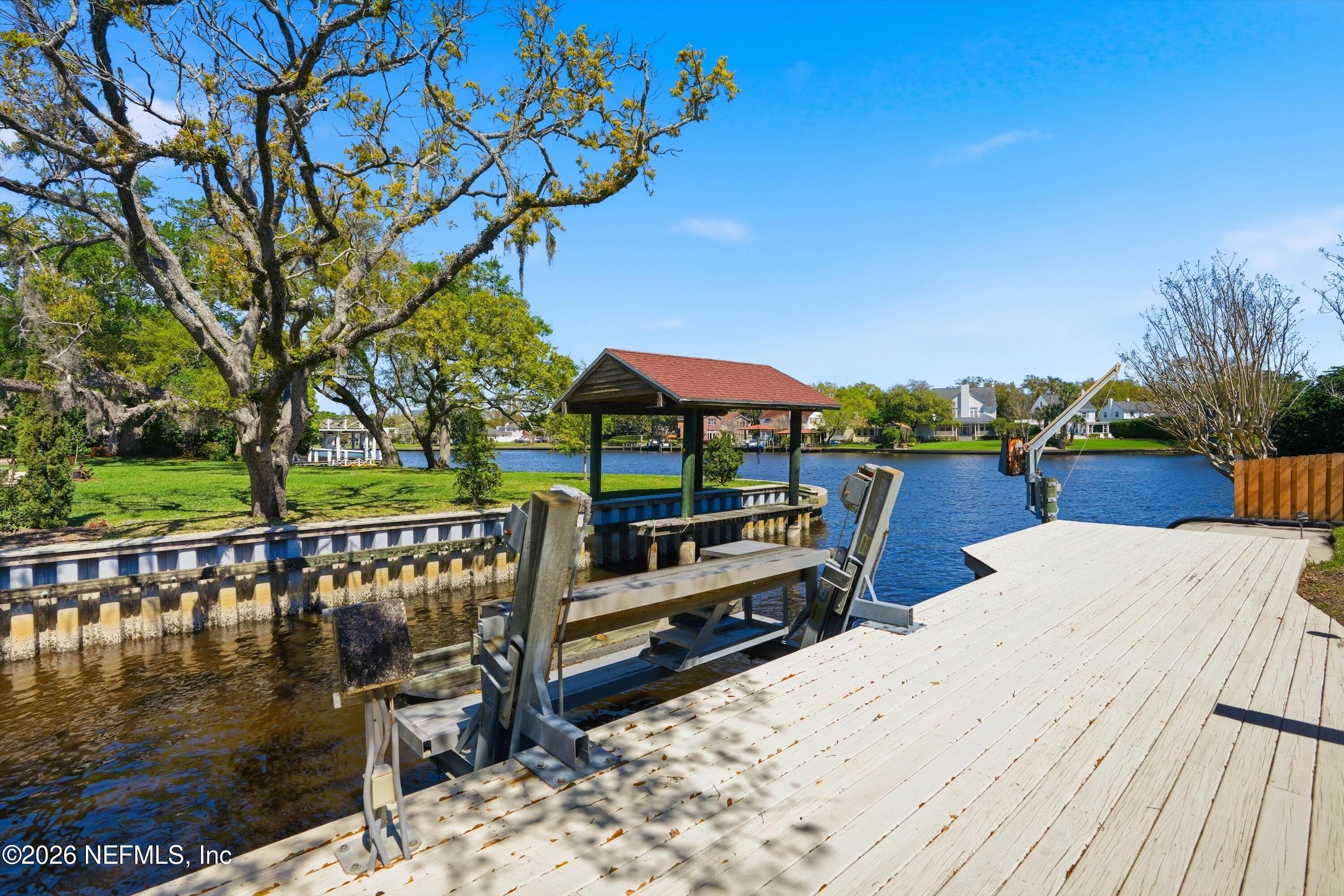 833 Sorrento Road Jacksonville, FL 32207 - Photo 49 of 68 a view of a roof deck with table and chairs a barbeque with wooden floor and fence