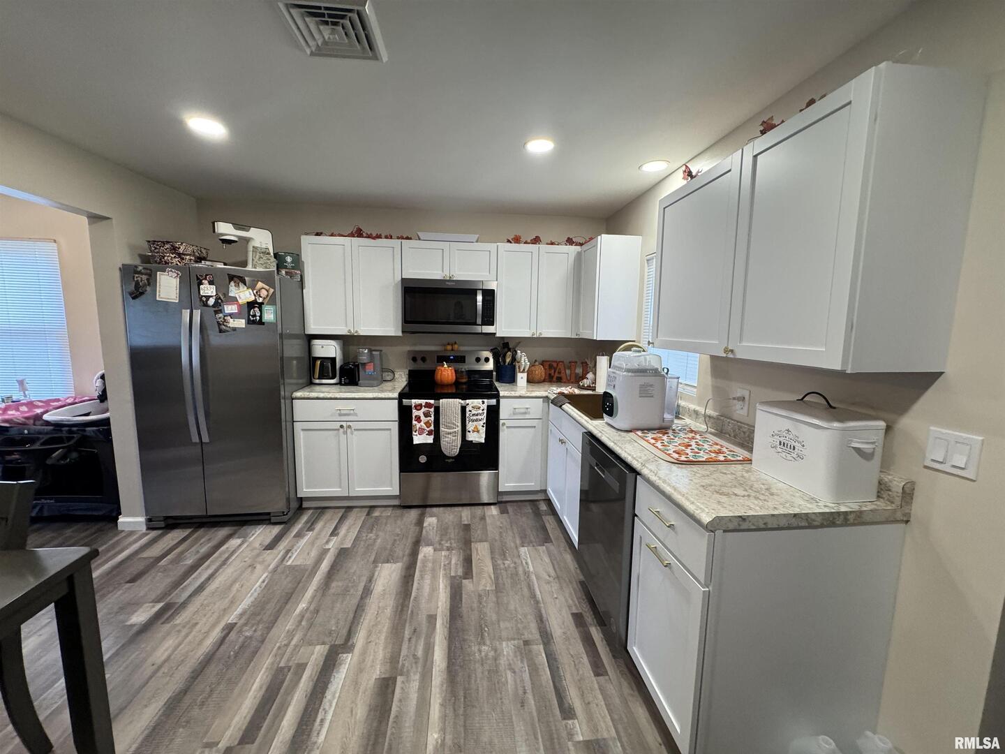 801 West 5th Street Flora, IL 62839 - Photo 35 of 48 a kitchen with a refrigerator a sink dishwasher and a stove with wooden floor