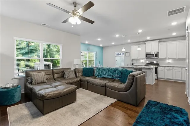 a living room with furniture kitchen and a large window