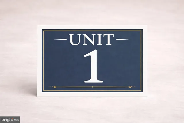 a view of an empty room with wooden floor and a fireplace