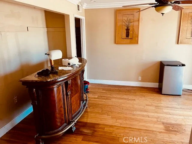 a view of an empty room with a window and a kitchen