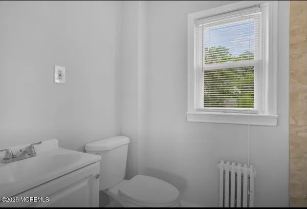 a bathroom with a toilet sink vanity and mirror