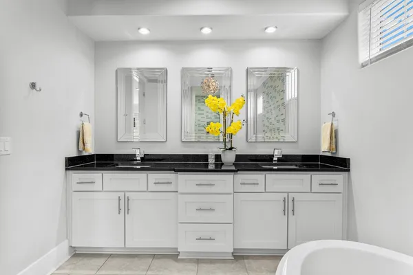 a bathroom with granite countertop a sink a toilet and mirror
