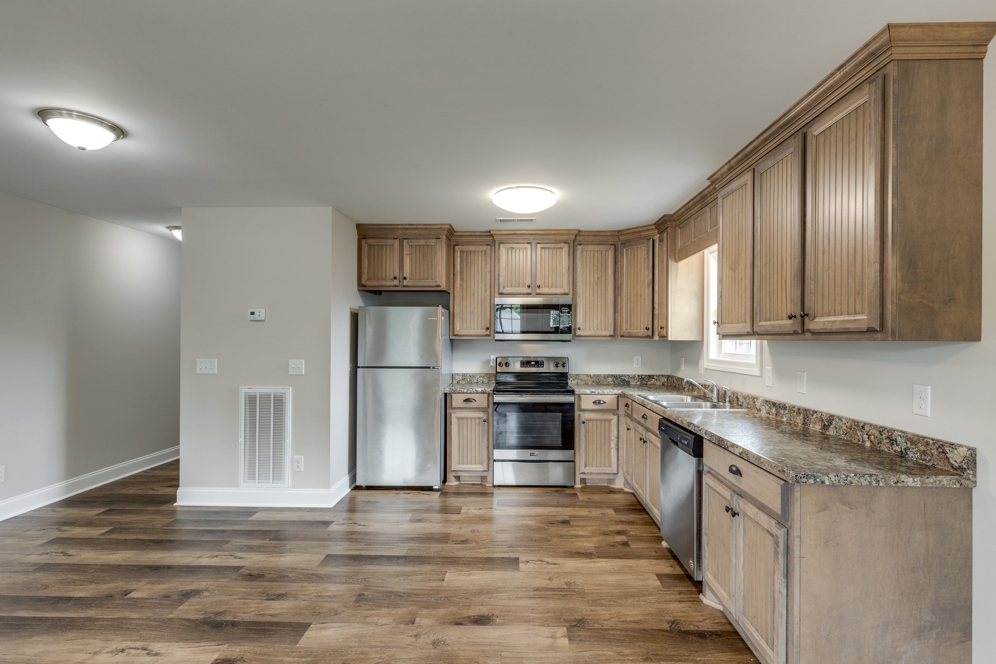 107 Ragsdale Lane Pulaski, TN 38478 - Photo 16 of 25 a kitchen with stainless steel appliances granite countertop a stove top oven a sink and dishwasher a refrigerator with wooden floors