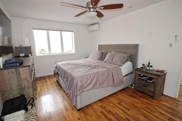a bedroom with a bed and a flat tv screen on dresser