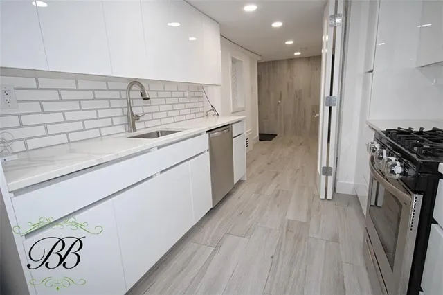 a kitchen with a sink and wooden floor