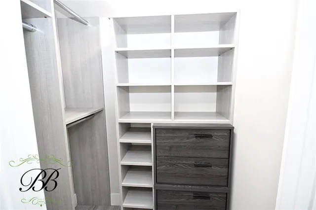 a view of walk in closet with empty racks
