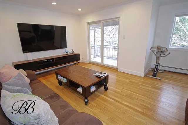 a living room with pool table flat screen tv and windows