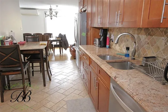 a kitchen with granite countertop a sink and white cabinets
