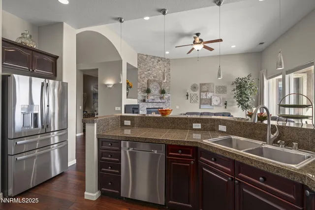 a kitchen with stainless steel appliances granite countertop a sink and a refrigerator
