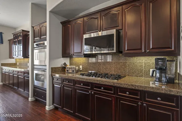 a kitchen with stainless steel appliances granite countertop a sink stove and microwave